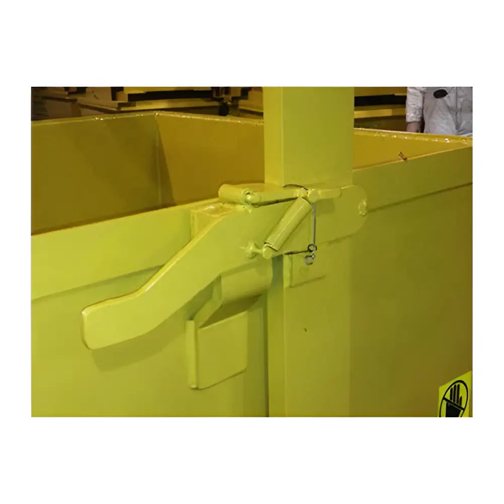 Close-up of yellow steel hopper latch mechanism with safety label.