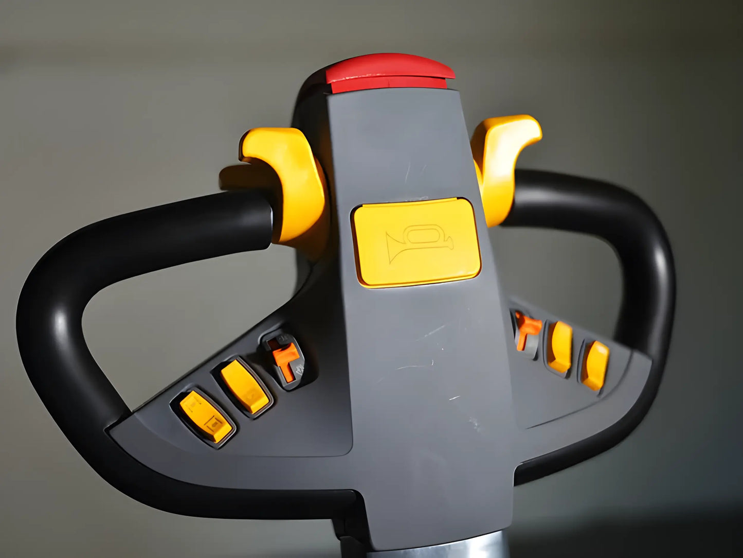 Close-up of forklift handle with control buttons and horn symbol.