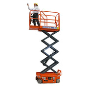 Ballymore drivable compact scissor lift in orange with an extended platform and person wearing a yellow hard hat
