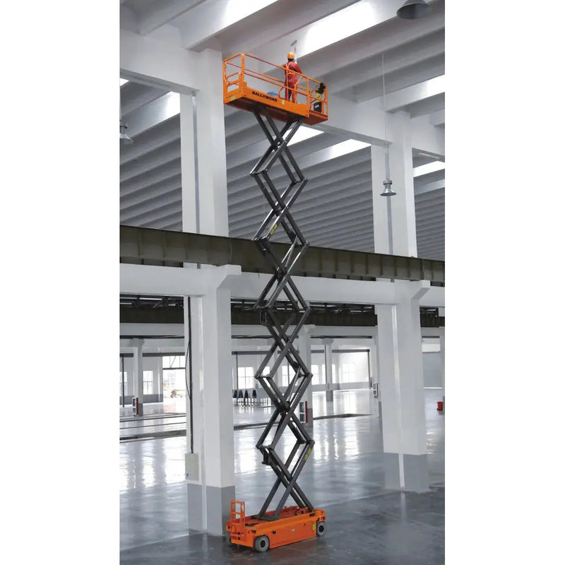 Ballymore drivable scissor lift in warehouse with worker operating elevated platform in orange
