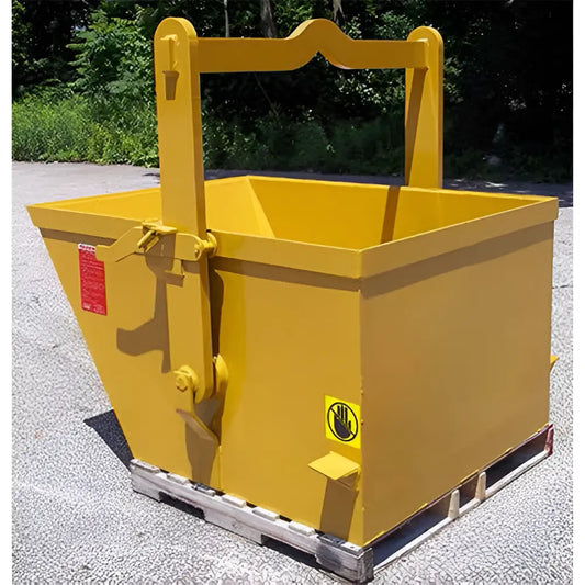 Yellow steel hopper with lifting handle placed on wooden pallet outdoors.