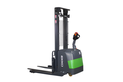 Electric stacker forklift with gray body, green accents, and lowered forks.