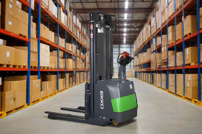 Electric stacker forklift with green accents in warehouse with stacked boxes.