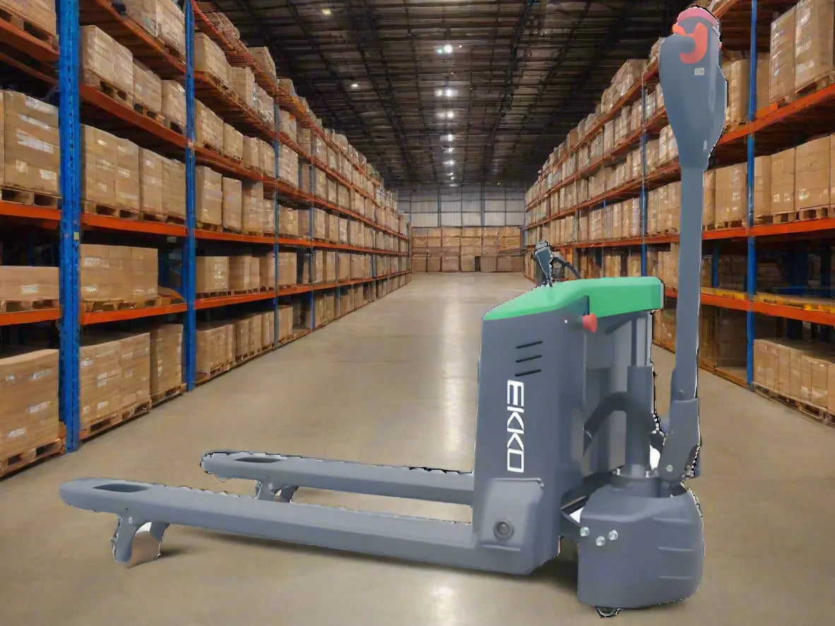 Electric pallet jack with green top in warehouse surrounded by shelves.