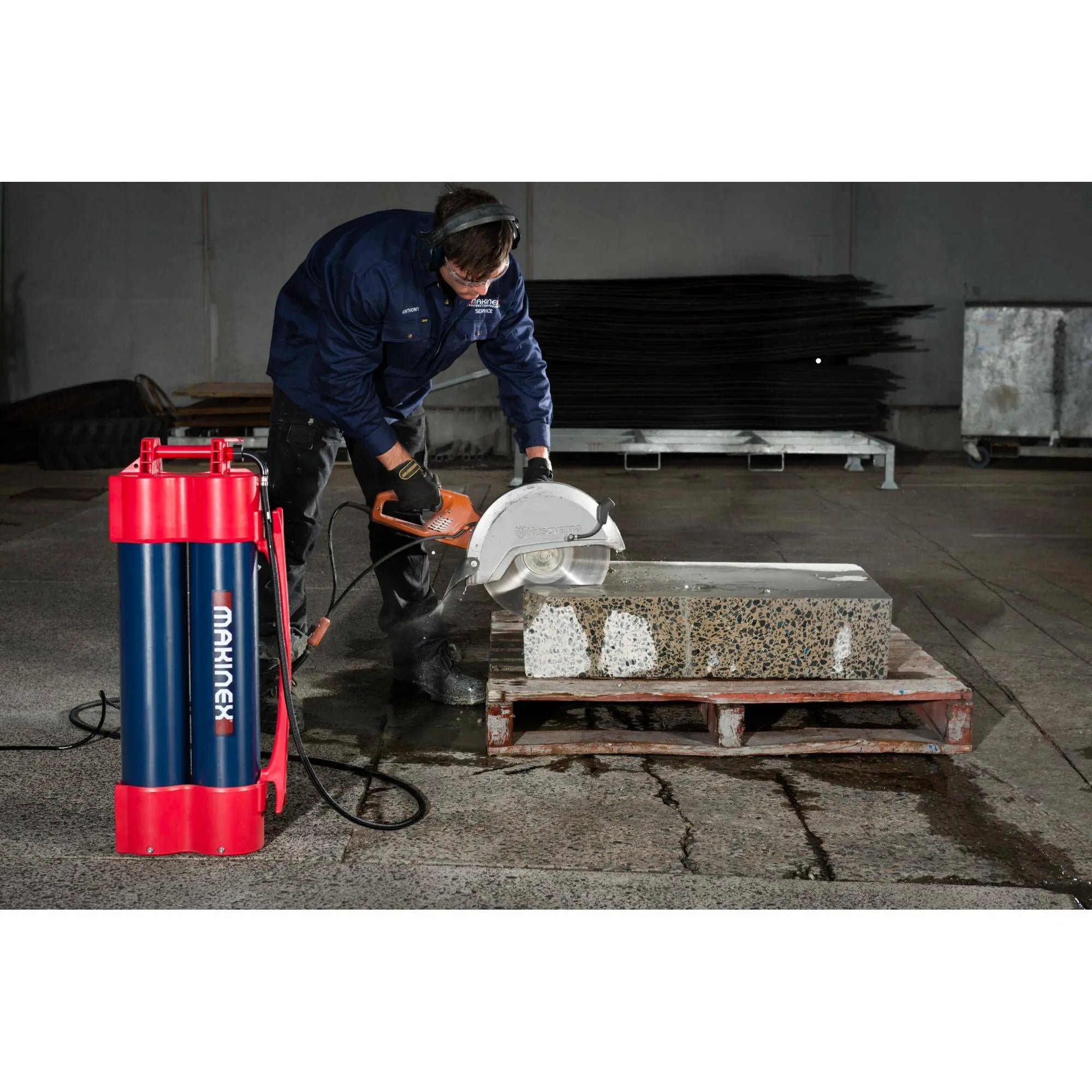 Worker using a saw with a Makinex water unit to cut concrete blocks