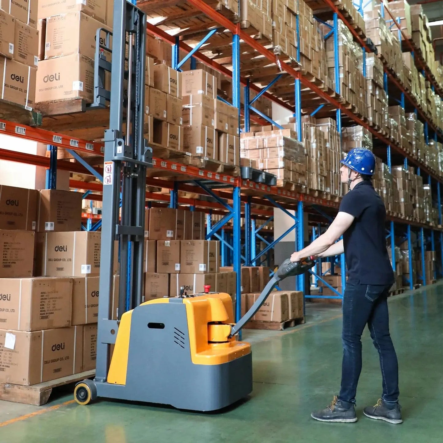 Apollolift A-3031 pallet stacker in warehouse lifting boxes by worker wearing blue helmet