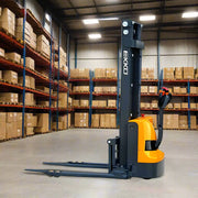 EKKO EB12EA electric pallet stacker in warehouse with orange and black design and extended forks