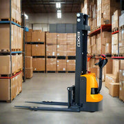 EKKO EB13E electric pallet stacker in warehouse with boxed goods on shelves