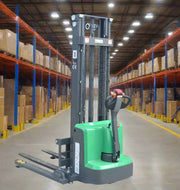 EKKO Electric Pallet Stacker with green base and black lifting mechanism in a warehouse aisle