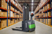 EKKO Electric Pallet Stacker in warehouse aisle lifting pallets with control handle and safety features