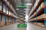 EKKO ES120E-LI green scissor lift extended in warehouse aisle with shelves full of boxes