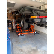 Katool Pneumatic Scissor Lift lifting a black sports car in a home garage for maintenance activities
