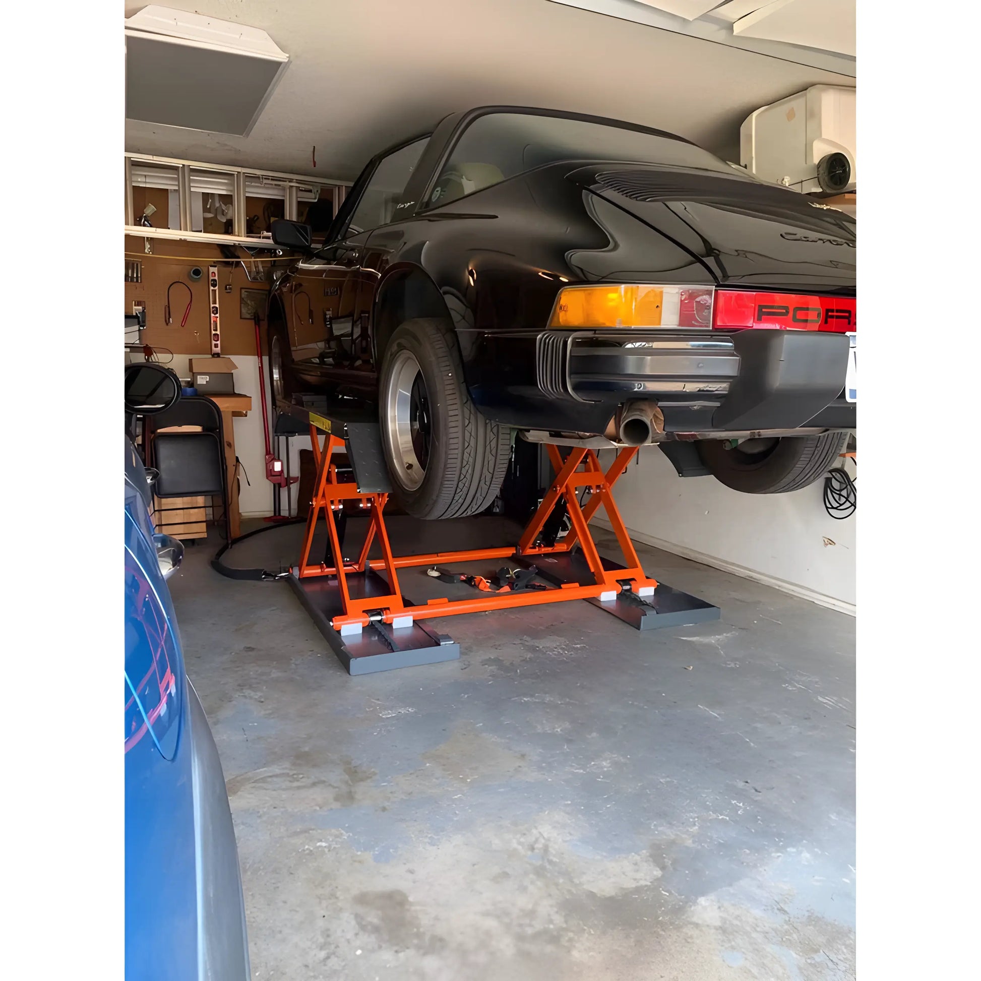 Katool Pneumatic Scissor Lift lifting a black sports car in a home garage for maintenance activities