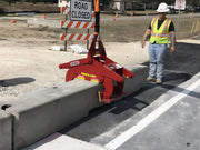 Kenco Concrete Barrier Lift in use, lifting a concrete barrier at a road construction site
