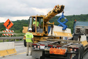 Kenco Concrete Barrier Lift in use by a construction worker on a highway for safe barrier placement