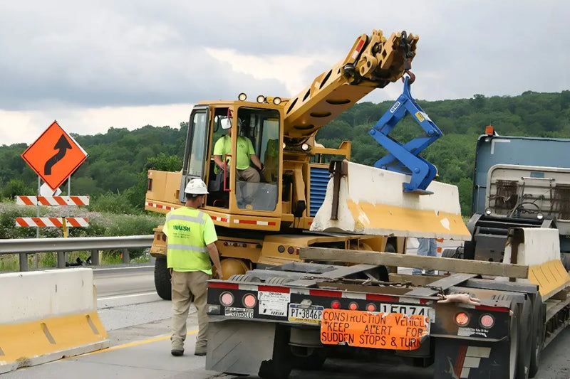 Kenco Concrete Barrier Lift in use by a construction worker on a highway for safe barrier placement