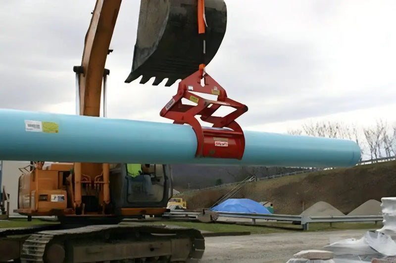 Kenco Concrete Pipe Lift in action lifting a large blue pipe with an excavator on a construction site
