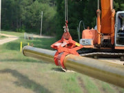 Kenco Concrete Pipe-Lift attached to a crane, lifting a concrete pipe at a construction site