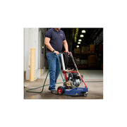 Man using Makinex DPC-2200-US pressure cleaner to clean concrete floor inside warehouse