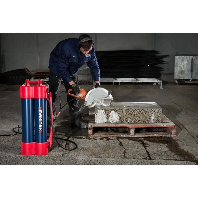 Worker using Makinex H2G-14 core drill machine to cut concrete slab in industrial setting