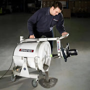 Man operating Makinex MS-100 concrete mixer pouring cement on floor in industrial setting