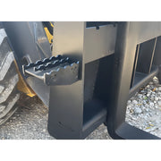 Close-up of the Star Industries 110EC-ITA heavy equipment attachment showing metal steps and tire on gravel surface