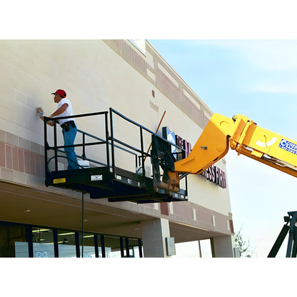Worker using Star Industries 1206C yellow aerial lift platform to clean building exterior