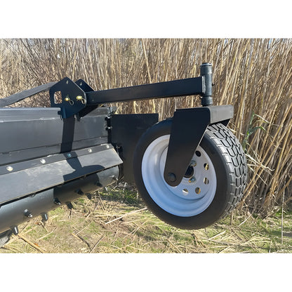 Close-up of Star Industries 130-72 black metal equipment with large tire on grassy field