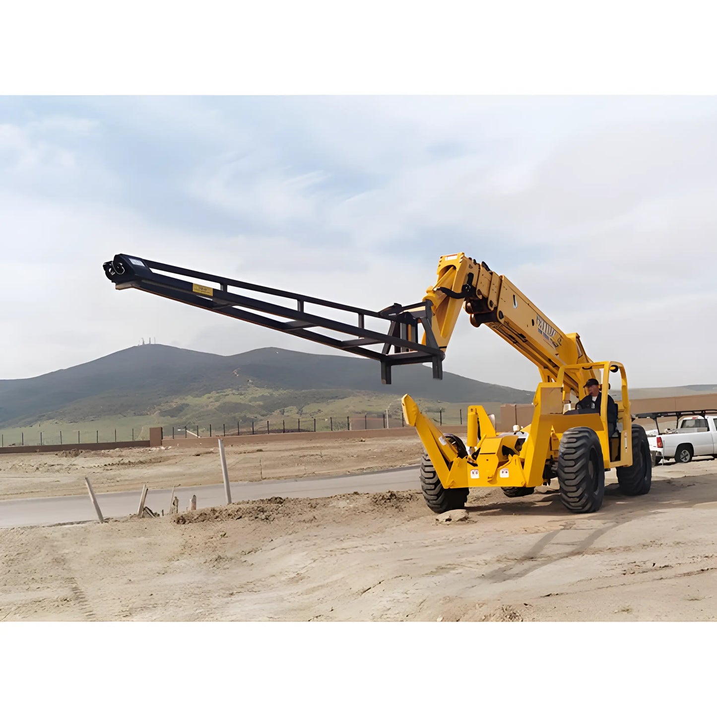 Star Industries 1335 yellow telescopic handler lifting arm at a construction site with hills in the background