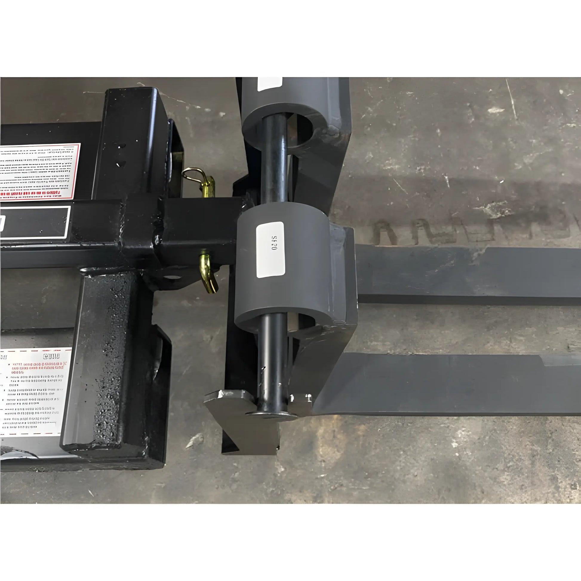 Close-up of Star Industries 1390-FM forklift attachment fork blades on concrete floor