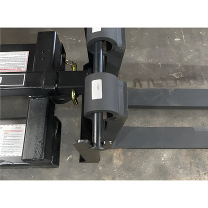 Close-up of Star Industries 1390-FM forklift attachment fork blades on concrete floor