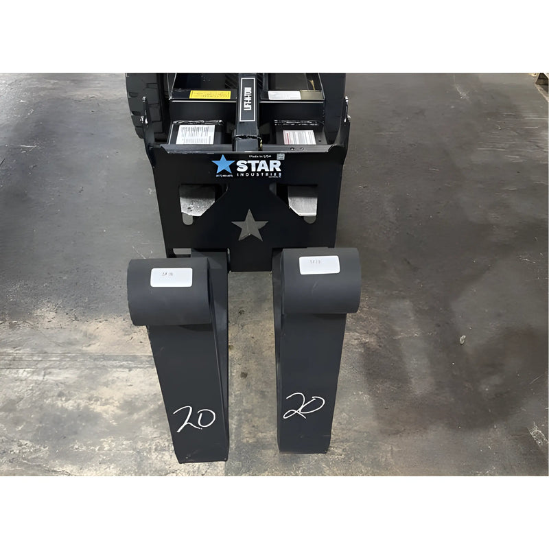Star Industries 1390-FM forklift fork extensions placed on a warehouse floor in front of a forklift