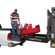 Man loading red equipment onto truck bed using Load N Tow with Star Industries 1398 model