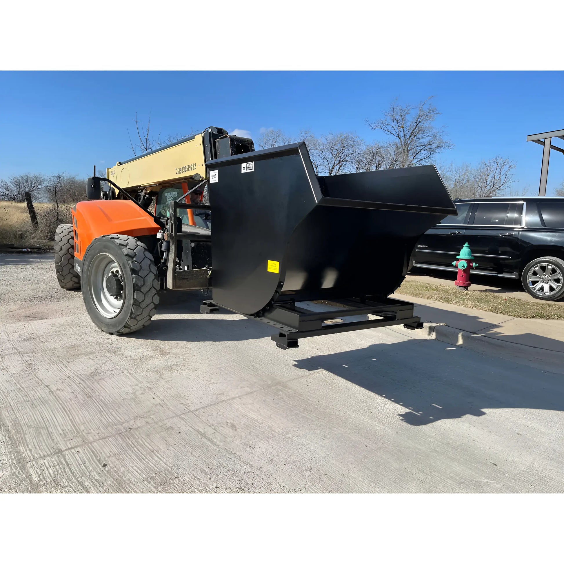 Star Industries 1820 self-dump hopper attached to heavy machinery on a concrete surface outdoors